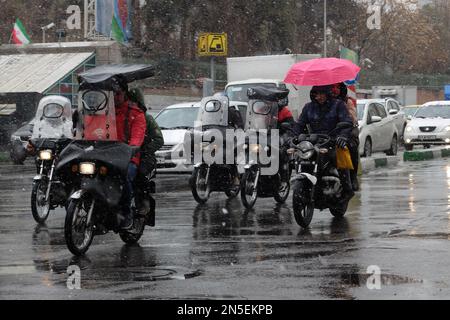 Teheran, Teheran, Iran. 9. Februar 2023. Motorräder fahren auf der Straße inmitten des Schnees in Teheran, Iran, am 09. Februar 2023. Der Leiter der Atomaufsicht der Vereinten Nationen unterstrich die Dringlichkeit, die diplomatischen Bemühungen zur Begrenzung des iranischen Atomprogramms wiederzubeleben, und erklärte, dass sich die Situation schnell verschlechtern könnte, wenn die Verhandlungen scheitern. (Kreditbild: © RouzbritFouladi/ZUMA Press Wire) NUR REDAKTIONELLE VERWENDUNG! Nicht für den kommerziellen GEBRAUCH! Kredit: ZUMA Press, Inc./Alamy Live News Stockfoto