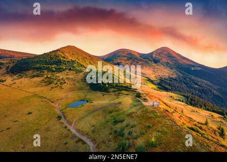 Wunderschöne Herbstlandschaft. Fantastischer Blick am Morgen auf das Touristenheim. Herrlicher Sonnenaufgang im Herbst in den Karpaten, in der Ukraine, in Europa. Die Schönheit der Natur Stockfoto