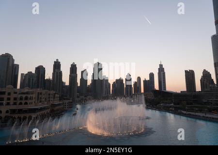 Dubai singende Brunnen bei Nacht Seeblick zwischen Wolkenkratzern. Moderne Architektur in der Dämmerung der Skyline der Stadt in der Innenstadt der Vereinigten Arabischen Emirate. Stockfoto