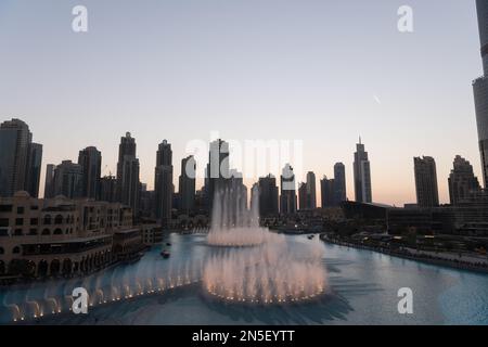 Dubai singende Brunnen bei Nacht Seeblick zwischen Wolkenkratzern. Moderne Architektur in der Dämmerung der Skyline der Stadt in der Innenstadt der Vereinigten Arabischen Emirate. Stockfoto