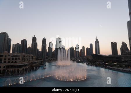 Dubai singende Brunnen bei Nacht Seeblick zwischen Wolkenkratzern. Moderne Architektur in der Dämmerung der Skyline der Stadt in der Innenstadt der Vereinigten Arabischen Emirate. Stockfoto