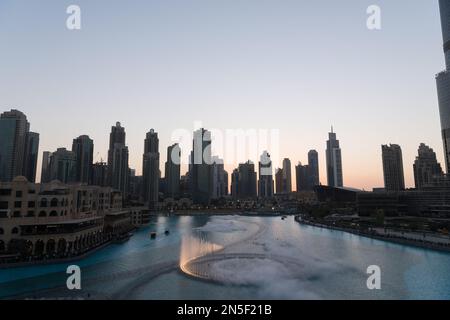Dubai singende Brunnen bei Nacht Seeblick zwischen Wolkenkratzern. Moderne Architektur in der Dämmerung der Skyline der Stadt in der Innenstadt der Vereinigten Arabischen Emirate. Stockfoto