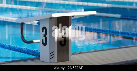 Startplattformen mit der Nummer 3 für Schwimmwettkämpfe. Swimmingpool ab Block 3. Sport- und Schwimmkonzept Stockfoto