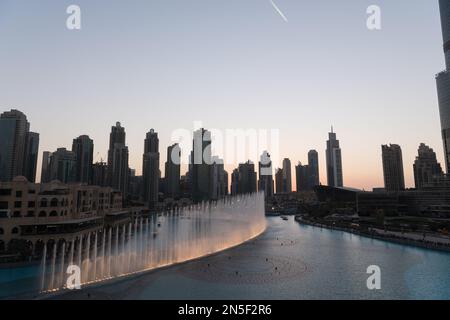 Dubai singende Brunnen bei Nacht Seeblick zwischen Wolkenkratzern. Moderne Architektur in der Dämmerung der Skyline der Stadt in der Innenstadt der Vereinigten Arabischen Emirate. Stockfoto