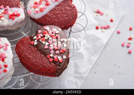 Valentinstag. Rote Samt- oder Brownie-Kekse in Herzform in Schokoladenoptik auf pinkfarbenem Hintergrund. Dessert-Idee für Valentinstag, Mütter oder Womens Da Stockfoto