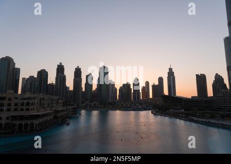 Dubai singende Brunnen bei Nacht Seeblick zwischen Wolkenkratzern. Moderne Architektur in der Dämmerung der Skyline der Stadt in der Innenstadt der Vereinigten Arabischen Emirate. Stockfoto