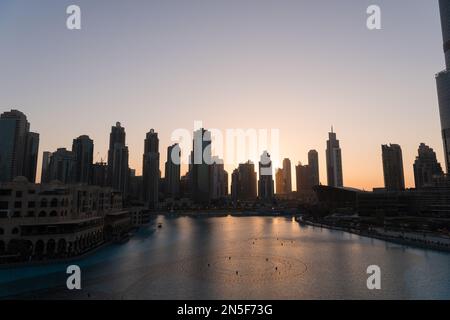 Dubai singende Brunnen bei Nacht Seeblick zwischen Wolkenkratzern. Moderne Architektur in der Dämmerung der Skyline der Stadt in der Innenstadt der Vereinigten Arabischen Emirate. Stockfoto