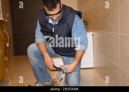 Praktischer Klempner, der Abflussrohre im Badezimmer mit einem Schraubenschlüssel repariert. Heimwerkerarbeit zu Hause Stockfoto