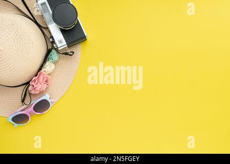 Komposition mit Strandzubehör und Platz für Text auf gelbem Hintergrund. Sommerurlaub, Urlaub, Reise und Reisekonzept. Flach liegend, Bannerdesign Stockfoto