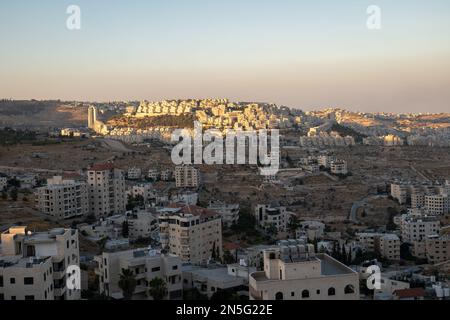 Bethlehem, Westjordanland, Palästina - 22. Juli 2022: Stadtbild in der Abenddämmerung mit letzten Sonnenstrahlen über den Gebäuden aus weißem Stein Stockfoto