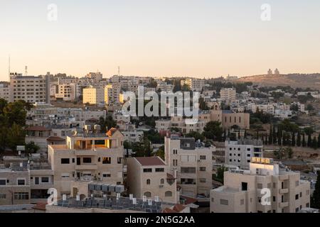 Bethlehem, Westjordanland, Palästina - 22. Juli 2022: Stadtbild in der Abenddämmerung mit letzten Sonnenstrahlen über den Gebäuden aus weißem Stein Stockfoto