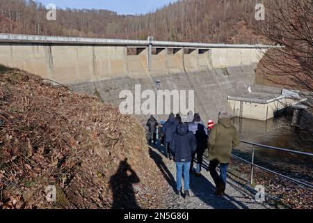 Wendefurth, Deutschland. 09. Februar 2023. Besucher gehen zum Eingangsbereich des Wendefurth-Staudamms. Während der Winterferien bietet der Talsperrenbetrieb Sachsen-Anhalt mehrmals täglich Führungen durch die Staumauer an. Sachsen-Anhalt verfügt über 33 Staudämme mit verschiedenen Dammhöhen und -Größen, die nicht nur wegen ihrer wirtschaftlichen Vorteile, sondern auch als lokale Erholungsziele beliebt sind. Kredit: Matthias Bein/dpa/Alamy Live News Stockfoto