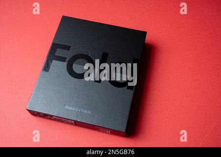 Brandneues Samsung Galaxy 4-Falz in Originalverpackung. Vor rotem Hintergrund. Stockfoto