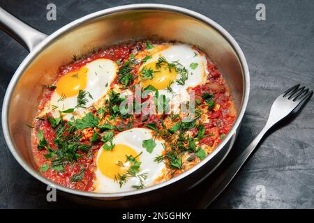 Leckeres und gesundes Shakshuka, nahöstliches Omelette in der Pfanne. Köstliches Rührei in scharfer Tomatenpfeffersauce Stockfoto