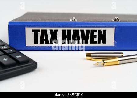 Geschäftskonzept. Auf einer weißen Oberfläche, einem Taschenrechner, einem Stift und einem Ordner mit der Aufschrift Tax Haven Stockfoto