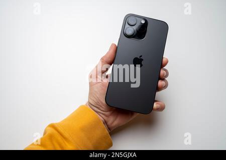 Ein Mann hat das neueste iPhone 14 Pro max in Space Black. Das neueste Apple-Telefon ist mit drei Kameras ausgestattet. Stockfoto