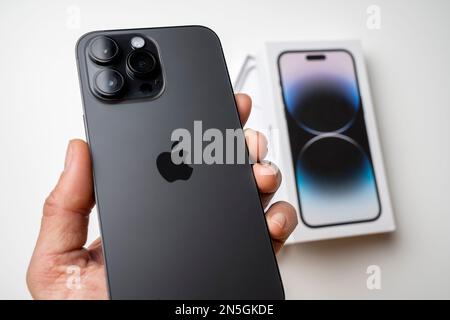 Ein Mann hat das neueste iPhone 14 Pro max in Space Black. Das neueste Apple-Telefon ist mit drei Kameras ausgestattet. Stockfoto