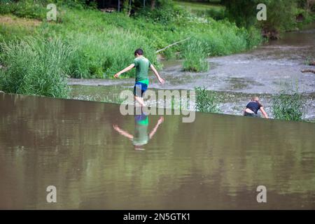 Kinder, die am Wehr des Flusses Diemel, Trendelburg, Kassel, Hessen, Deutschland, spielen Stockfoto