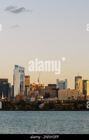 Vollmond über der skyline von boston bei Sonnenuntergang am vordergrund des charles River Stockfoto