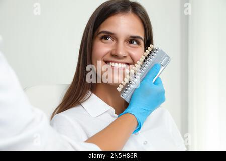 Arztprüfung der Zahnfarbe junger Frauen in der Klinik. Kosmetische Zahnheilkunde Stockfoto