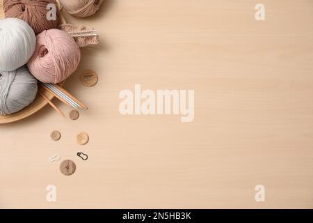 Flache Verlegung mit Fäden und Bastelzubehör auf Holztisch, Platz für Text. Fesselndes Hobby Stockfoto