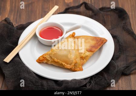 Zwei Samosas mit Fleisch und Gemüse auf einem kleinen weißen Teller Stockfoto