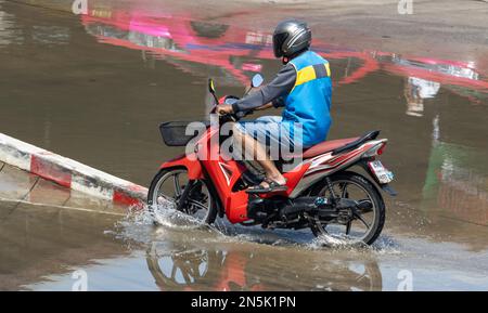 Der Fahrer des Mottotaxi in einer blauen Weste fuhr auf der nassen Straße, Thailand Stockfoto