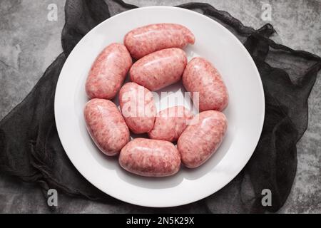 Gerolltes Botifarra, eine für Katalonien typische Schweinefleischwurst in einem weißen Gericht Stockfoto