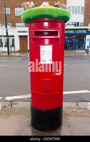 Eine Strickmütze für Tierschutz, die oben auf einem späten – wahrscheinlich eines der letzten – QE2/QEll/Queen Elizabeth-Säulenkasten/Post-/Briefkasten angebracht wurde, der 2022 in Twickenham, London, installiert wurde. UK (133) Stockfoto