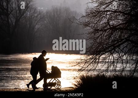 Stuttgart, Deutschland. 09. Februar 2023. Bei sonnigem Wetter spaziert eine Familie am Max Eyth Lake entlang. Kredit: Christoph Schmidt/dpa/Alamy Live News Stockfoto