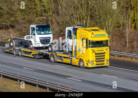 HENDRICKS International Car Transporter SCANIA 590 S mit ROLFO-Anhänger und neuen DAF LF-Zugmaschinen; Fahrt auf der Autobahn M61 UK Stockfoto