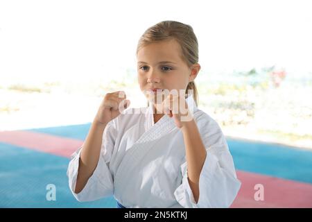 Ein Mädchen in Kimono, das draußen Karate auf Tatami übt Stockfoto