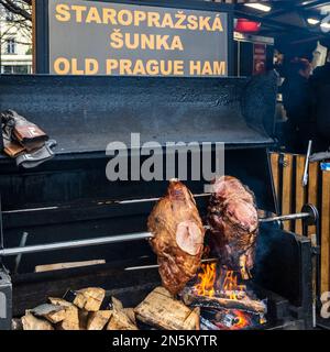 Zwei Portionen Old Praue Ham werden über einem offenen Kaminfeuer auf dem Prager Altstädter Ring gekocht Stockfoto