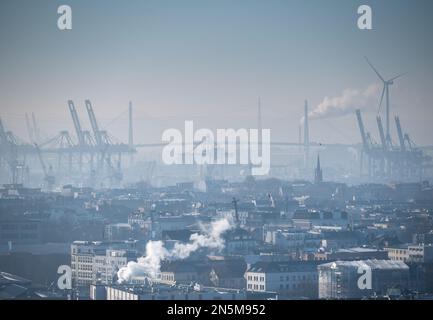 Kalter und nebiger Tag in Hamburg. Bild vom Stadtzentrum, Kraniche im Hafen und die Koehlbrandbrücke in der Ferne. Stockfoto