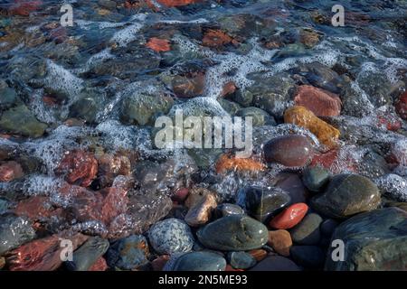 Steine am Meeresrand an einem Strand in Schottland. Stockfoto
