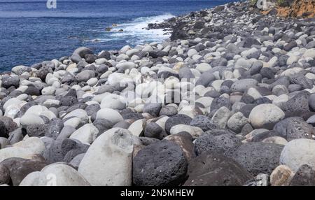 An einem Strand in Sao Miguel wurden im Meer runde Steine gewaschen Stockfoto