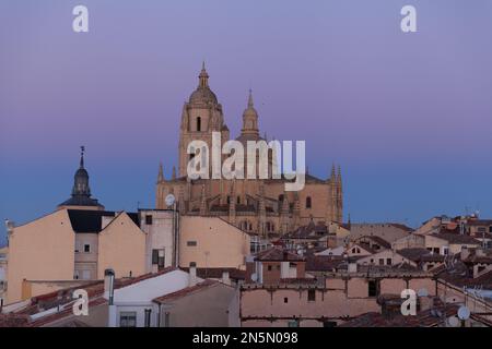 Segovia, Spanien - 4. Januar 2022: Panoramablick auf Segovia mit den Türmen der Kathedrale bei Sonnenuntergang und dem violetten bis blauen Himmel im Winter mit Guad Stockfoto