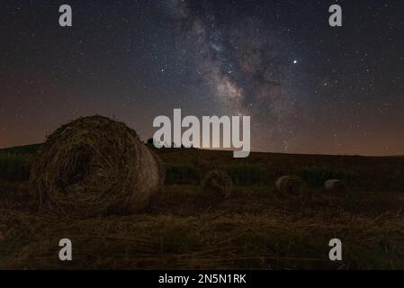 Nachtansicht mit der Milchstraße eines Heuballen-Feldes, Sizilien Stockfoto