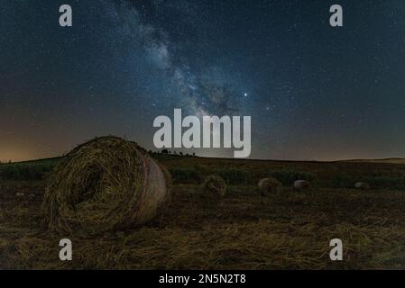 Nachtansicht mit der Milchstraße eines Heuballen-Feldes, Sizilien Stockfoto