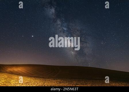 Nachtansicht mit Milchstraße eines gepflügten Landes im sizilianischen Hinterland, Italien Stockfoto