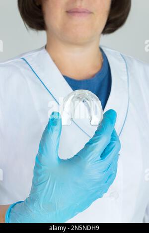 Zahnbleichung - Zahnablage in der Hand des Arztes, Nahaufnahme. Unsichtbare abnehmbare Halterungen für die kieferorthopädische Behandlung Stockfoto