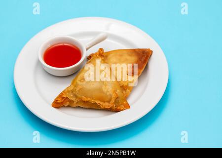 Zwei Samosas mit Fleisch und Gemüse auf weißem Teller Stockfoto