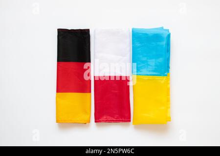 Drei Flaggen Deutschlands, der Ukraine und Polens auf weißem Hintergrund, Vereinigung und Union Stockfoto