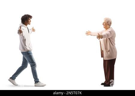 Ein junger afroamerikanischer Mann, der auf eine weiße ältere Frau zugeht, isoliert auf weißem Hintergrund Stockfoto