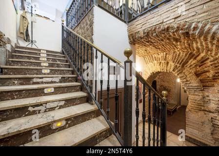 Treppen eines Restaurants mit freiliegender Ziegelbasis und schmiedeeisernem Geländer Stockfoto