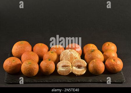Tangerinen aus dem ökologischen Garten auf dunklem Hintergrund. Stockfoto