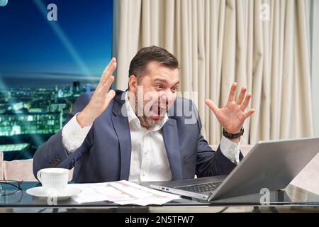 Wütender Geschäftsmann hat Videoanruf. Streit, gestresster Büroangestellter, Remote-Arbeit. Enttäuschung Stockfoto