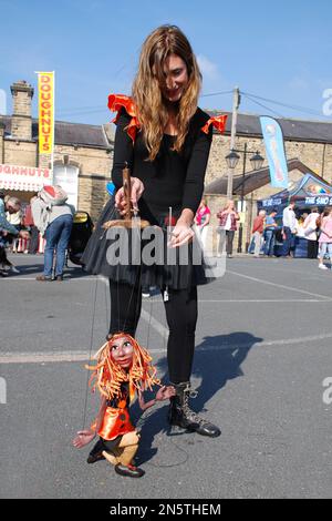 Der Puppenspieler unterhält die Kinder beim Skipton Puppet Festival und erweckt die Illusion, dass die Puppe lebt. Stockfoto