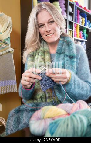 Porträt einer reifen Frau, die Schalldämpfer strickt, Bayern Stockfoto