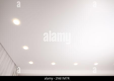 Weiße Stretch-Decke mit Spots im Zimmer, Blick aus niedrigem Winkel Stockfoto